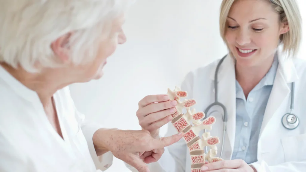 A doctor and patient consultation on the patient suffeirng from back aches caused by osteoporosis.