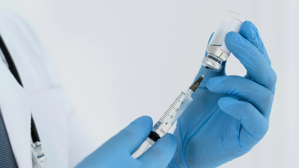 A medical professional preparing the osteoporosis treatment for their patient.