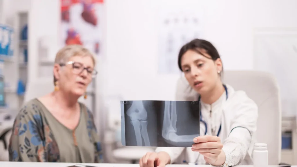 A patient undergoing a consultation with a medical professional, explaining an x-ray and the osteoporosis treatment guidelines.