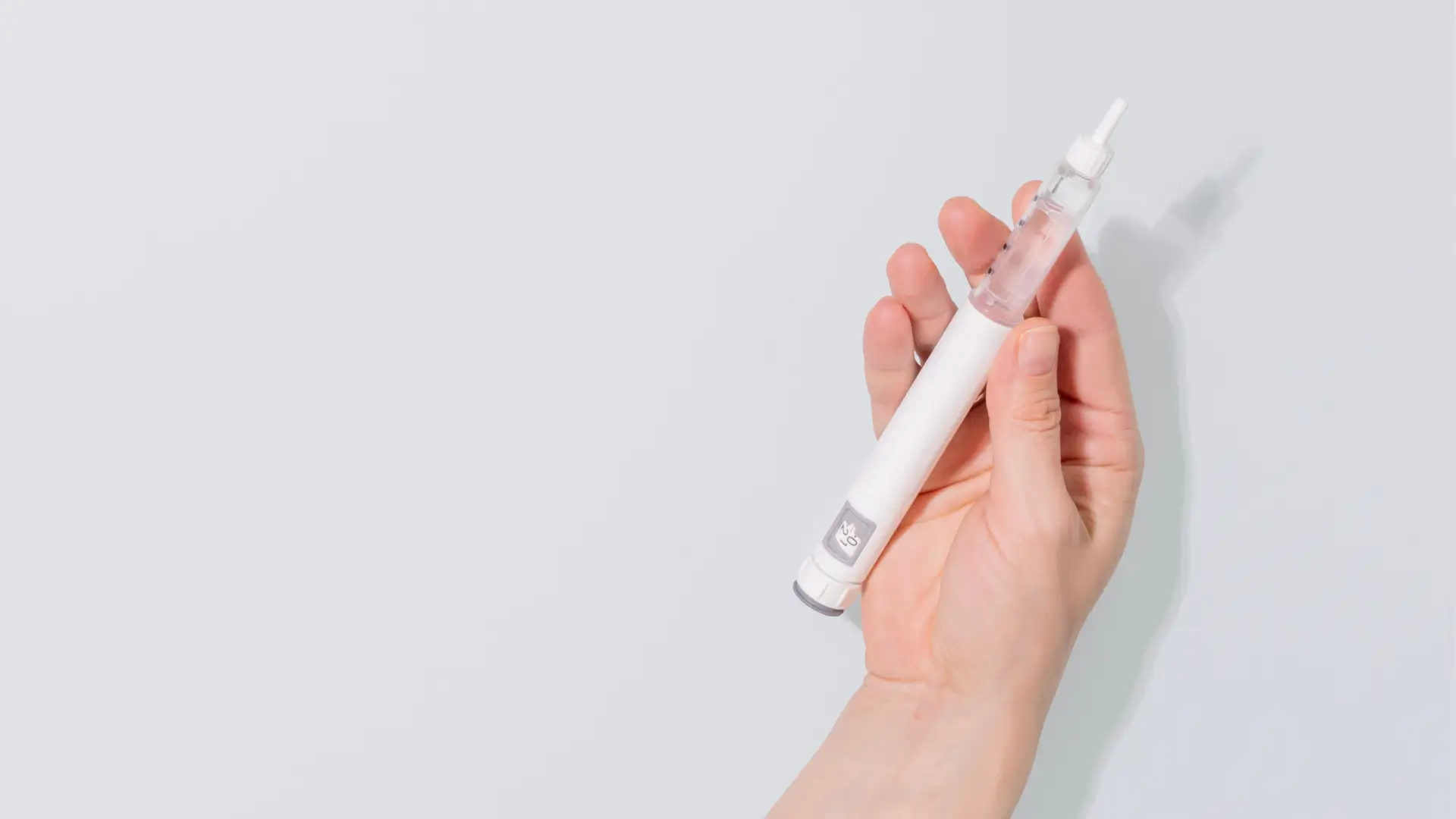 A medical professional holding a retatrutide for cholesterol injection, a triple agonist mechanism therapy.