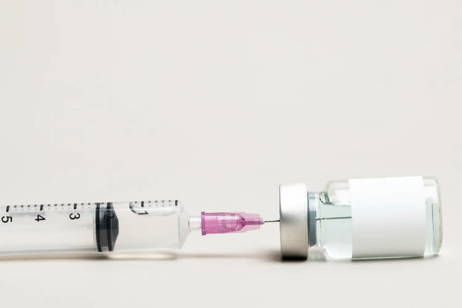 A close-up shot of a medical injection and vial with a formulation, like retatrutide, semaglutide, or tirzepatide.